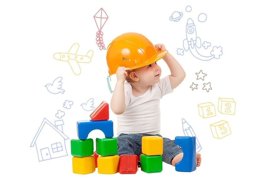 Kid with a construction hat and learning blocks at KidAble